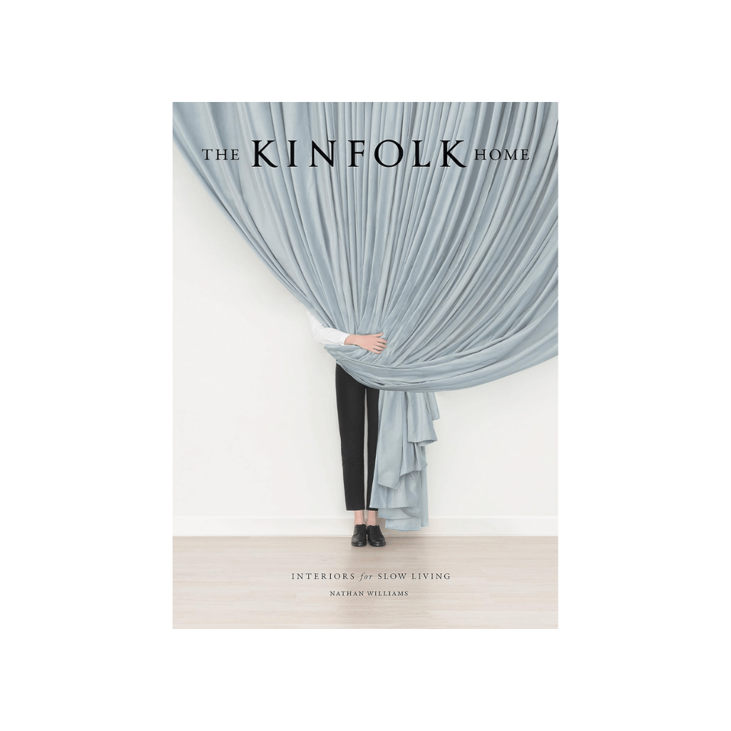The Kinfolk Home by Nathan Williams, exploring slow living and mindful home books for 2026. Book cover featuring a person standing behind voluminous, pale blue curtains.