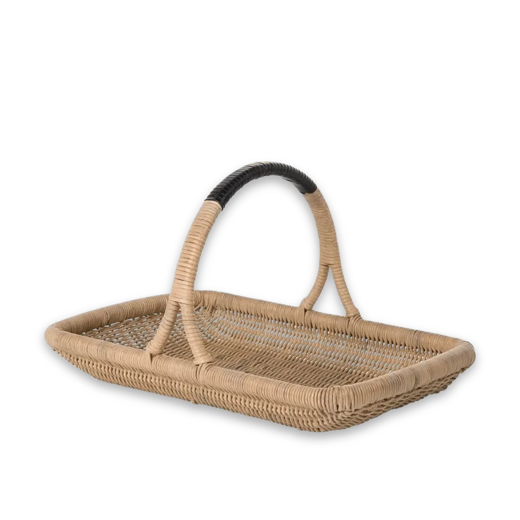 A traditional woven rattan harvest trug with a dark handle for gathering flowers in a vintage-inspired garden.